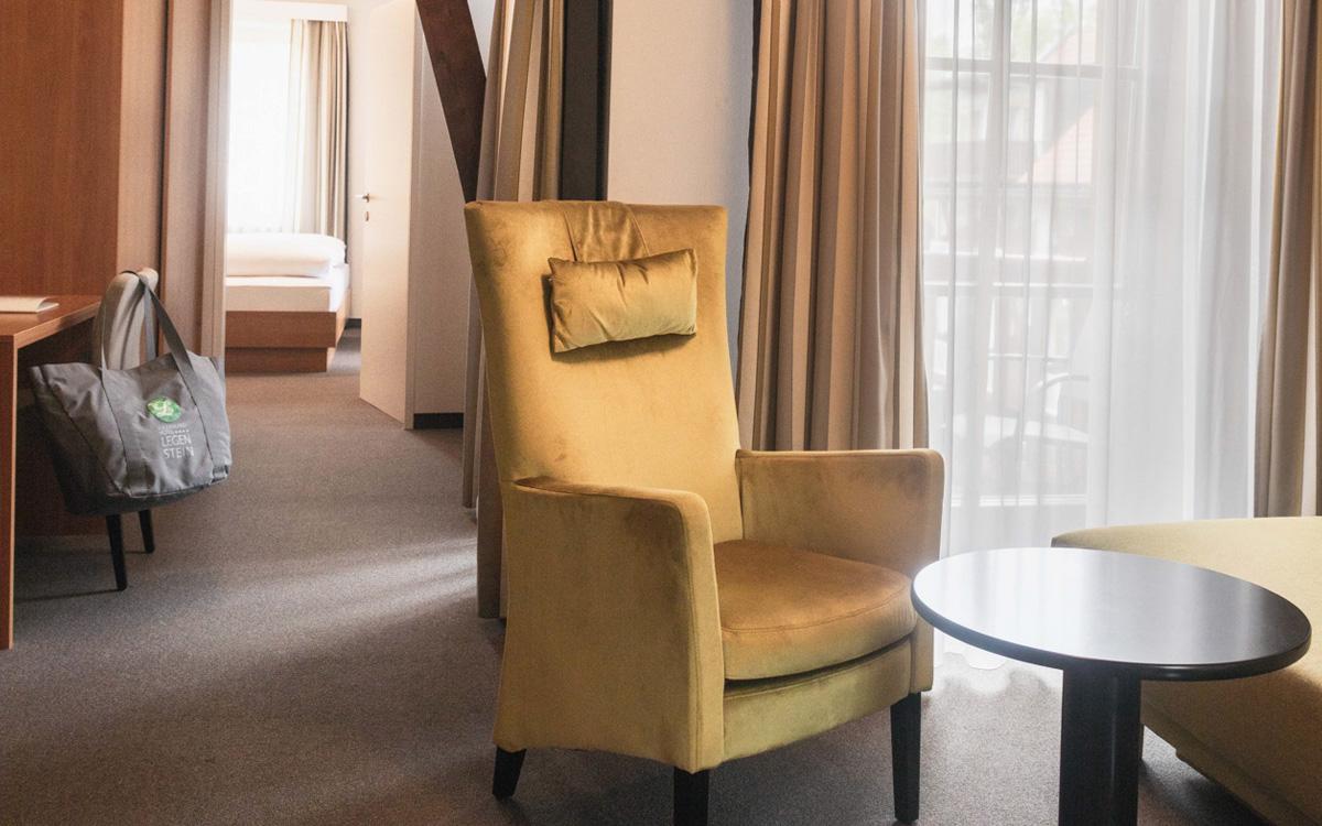 Wohnraum mit gemütlichem Sessel in glänzendem gelbgrün in der Suite Steinriegel Preise im Vulkanlandhotel Legenstein in Bad Gleichenberg