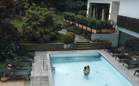 ein pärchen schwimmt im pool und genießt den warmen sommerregen im vulkanlandhotel legenstein in bad gleichenberg